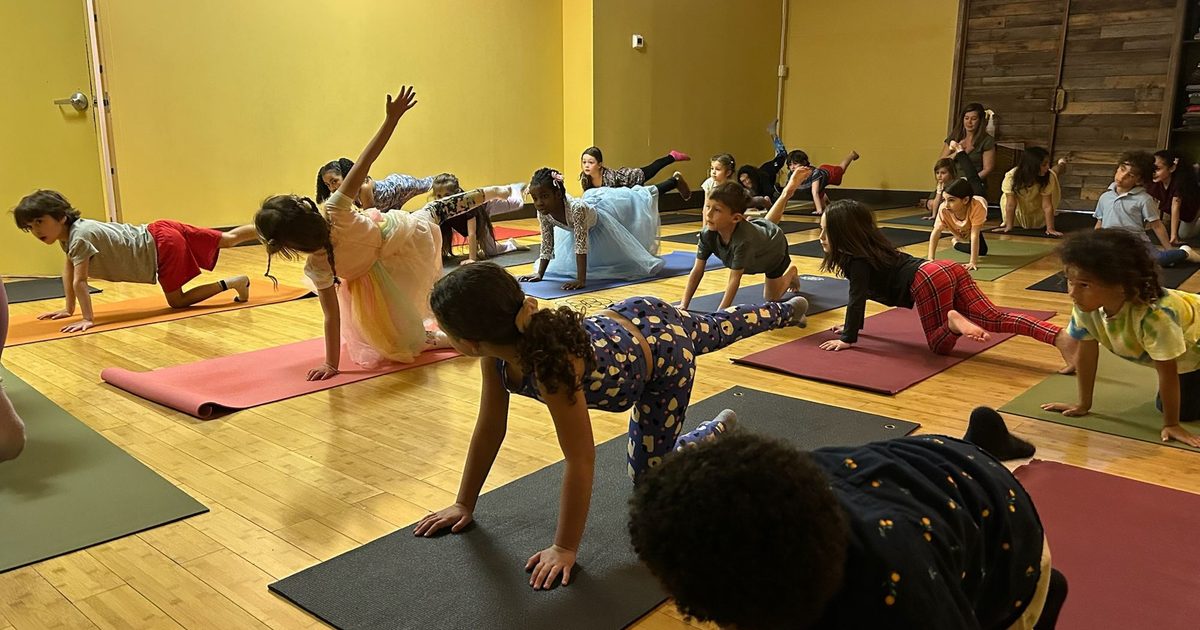 Children balancing on their mats in a kids yoga class at Revolution Yoga in Rockville Centre