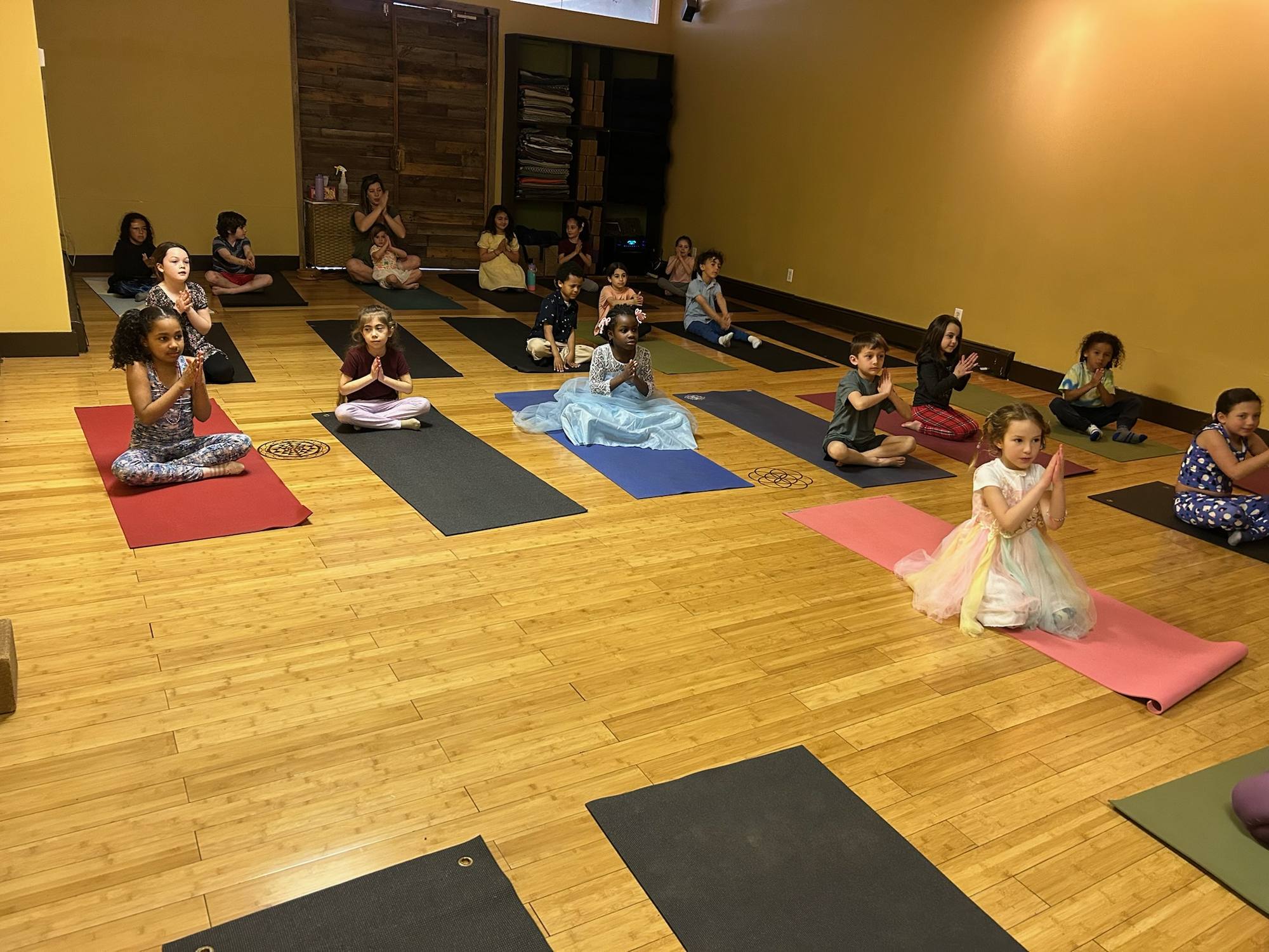 Kids seated on colorful mats in a kids yoga class in Rockville Centre