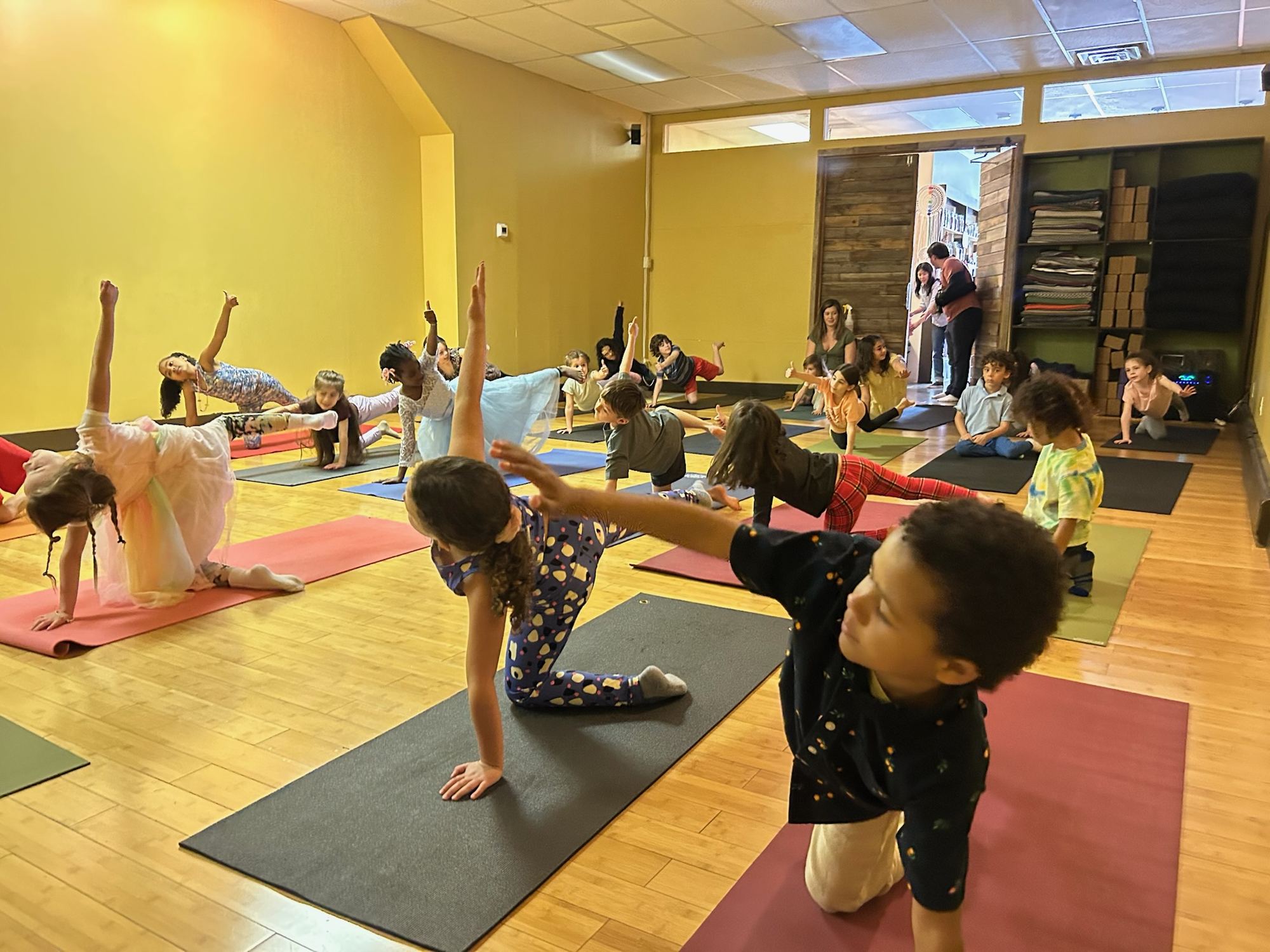 Kids balancing on hands and knees at a pajama yoga party