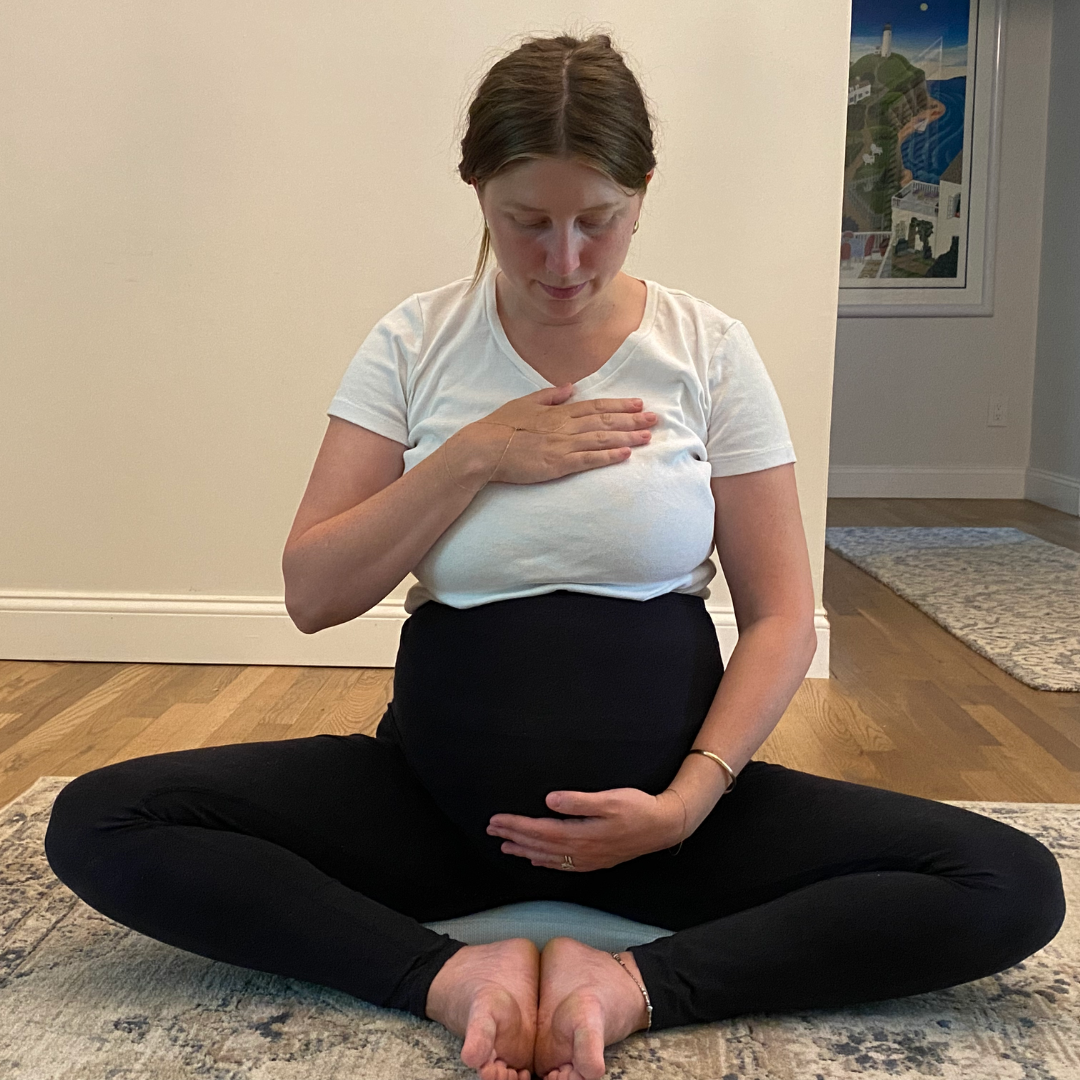 Pregnant student in meditation, supportive teacher hand on shoulder
