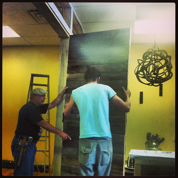 Installing the original wooden studio door, built by hand from repurposed material