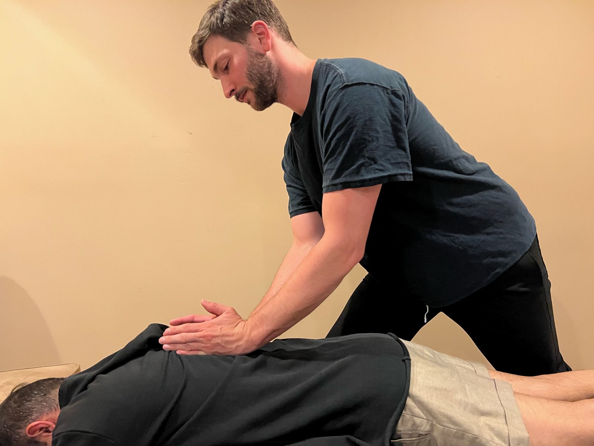 Dr. Keith Angrisani giving a chiropractic adjustment to a client on the table