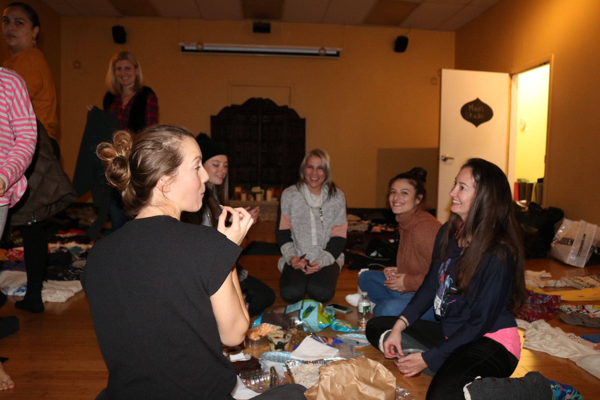 Women chatting in a circle at a Revolution Yoga family celebration