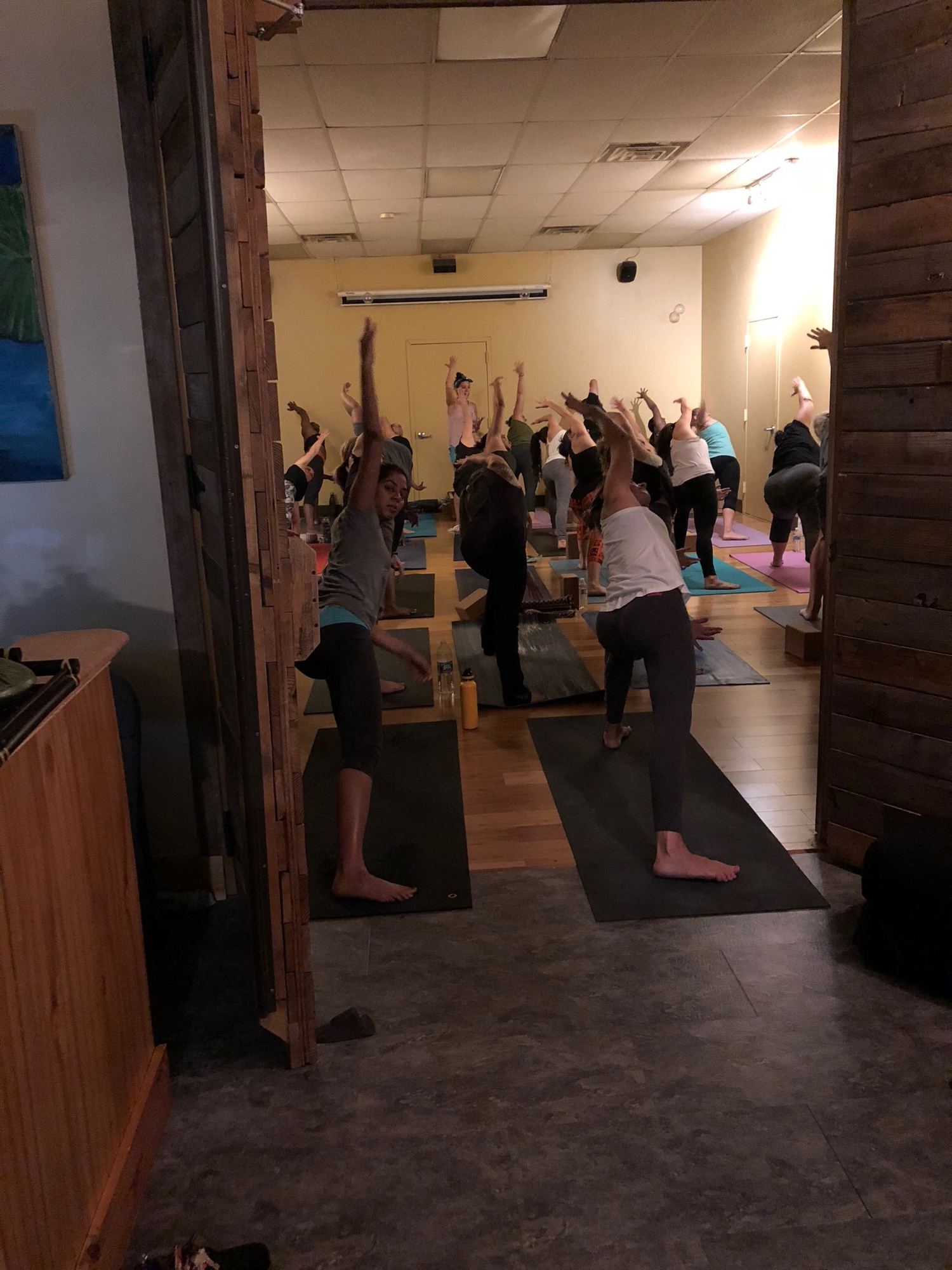 Adults practicing yoga together at a Revolution Yoga wellness celebration