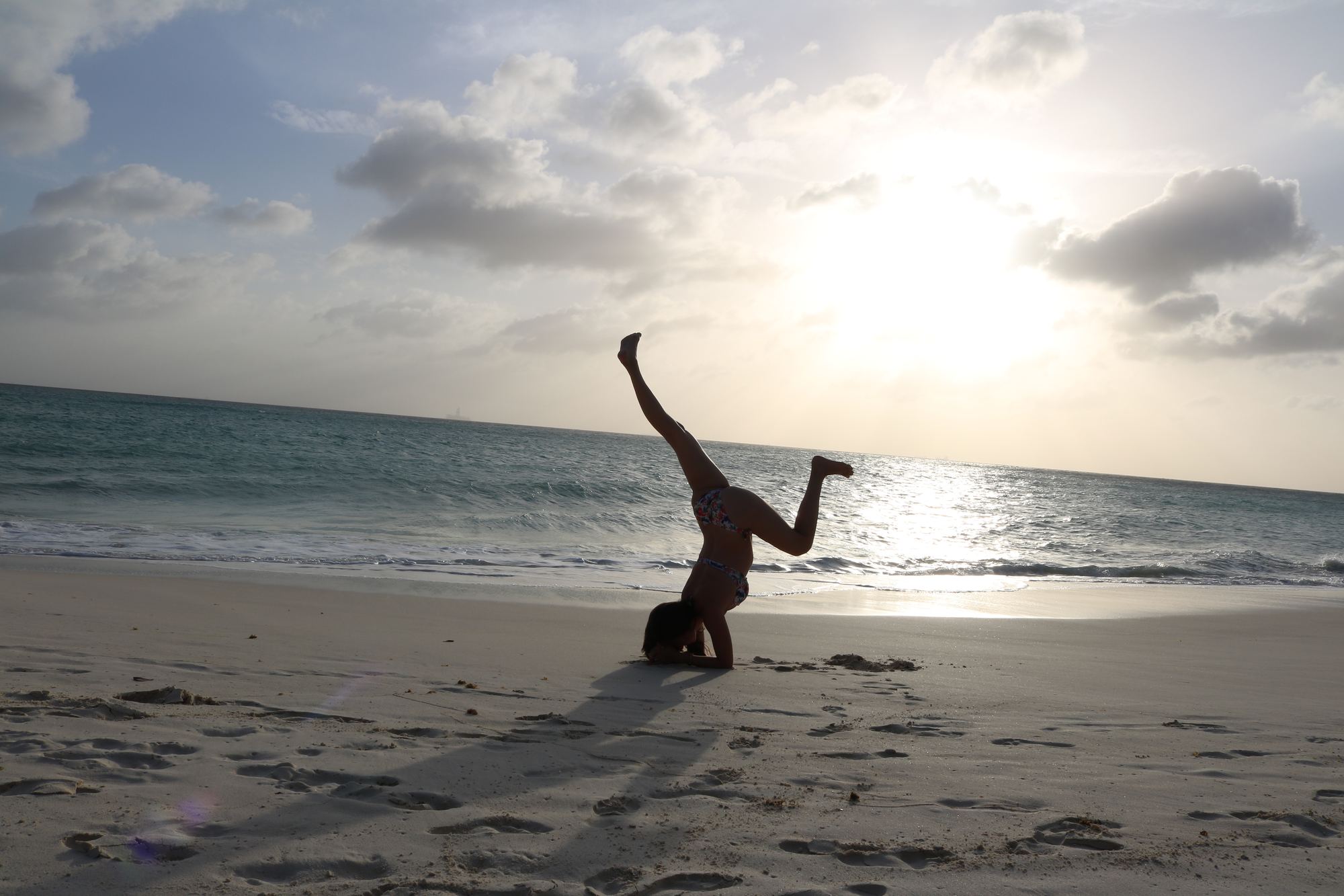 Yoga headstand on the beach at sunrise