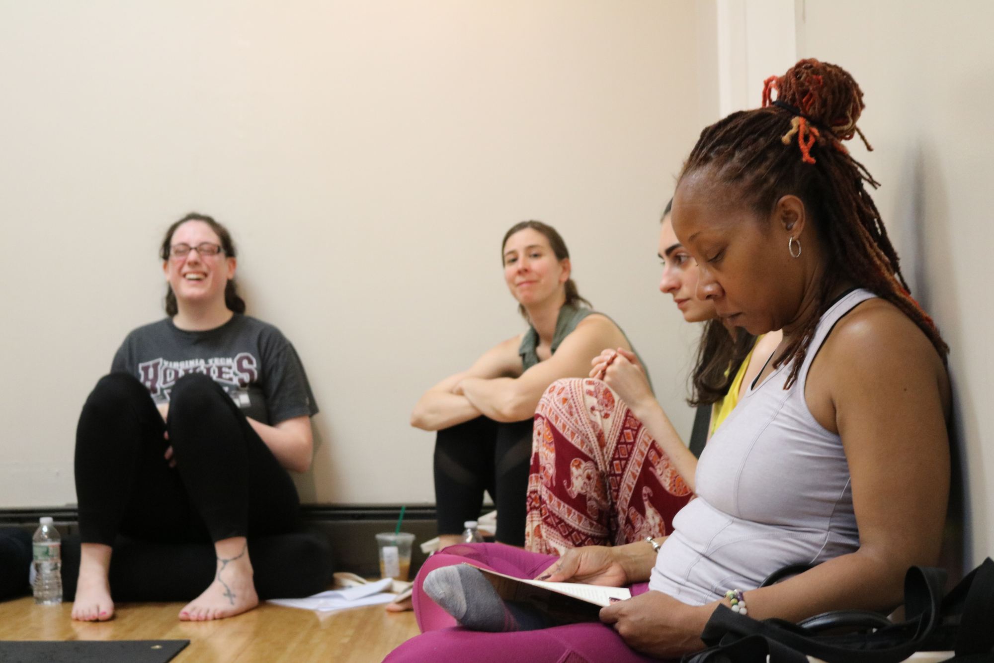 Yoga teacher trainees chatting with notebooks during a training day