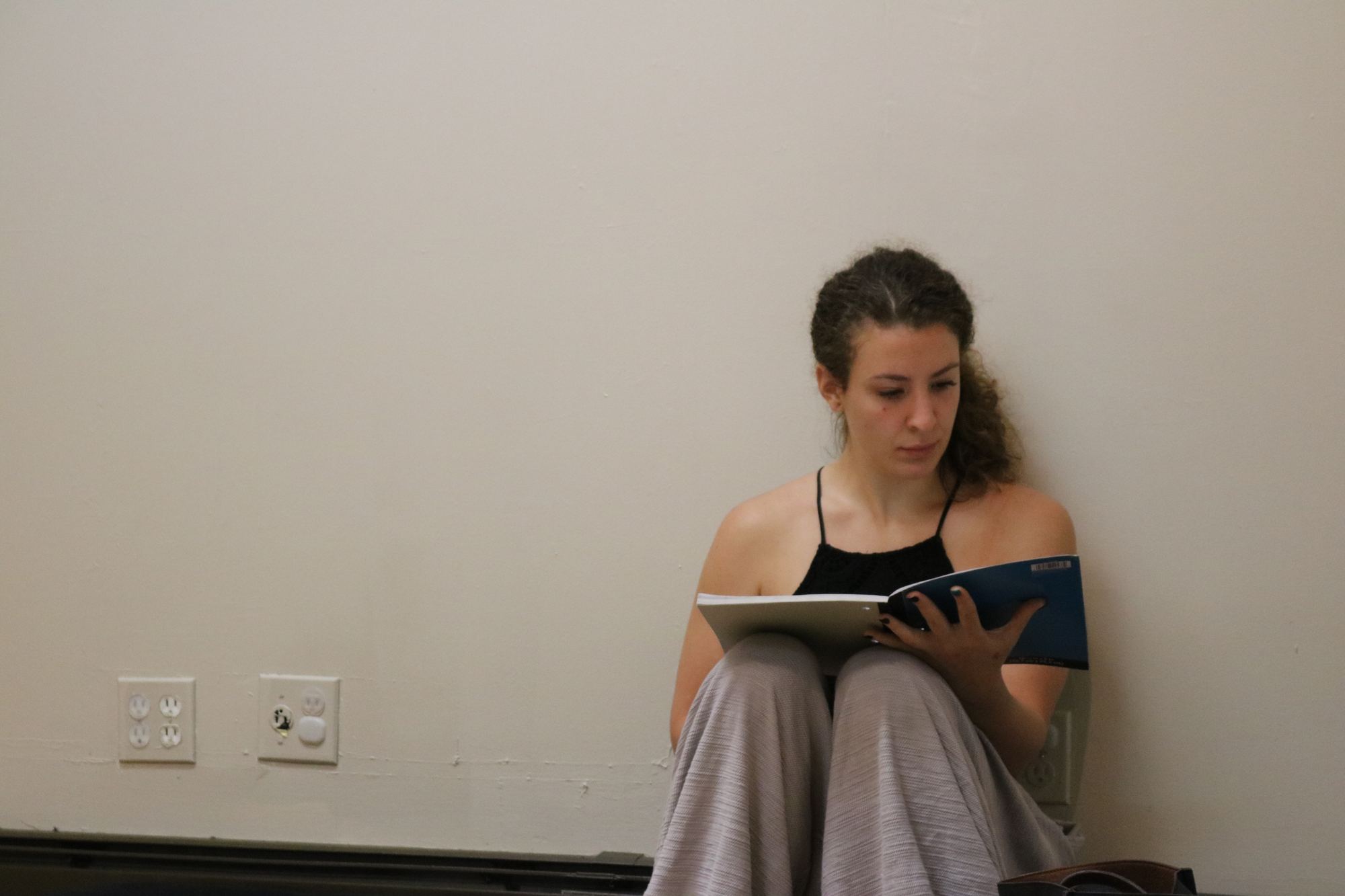 Teacher trainee studying course notes against the studio wall