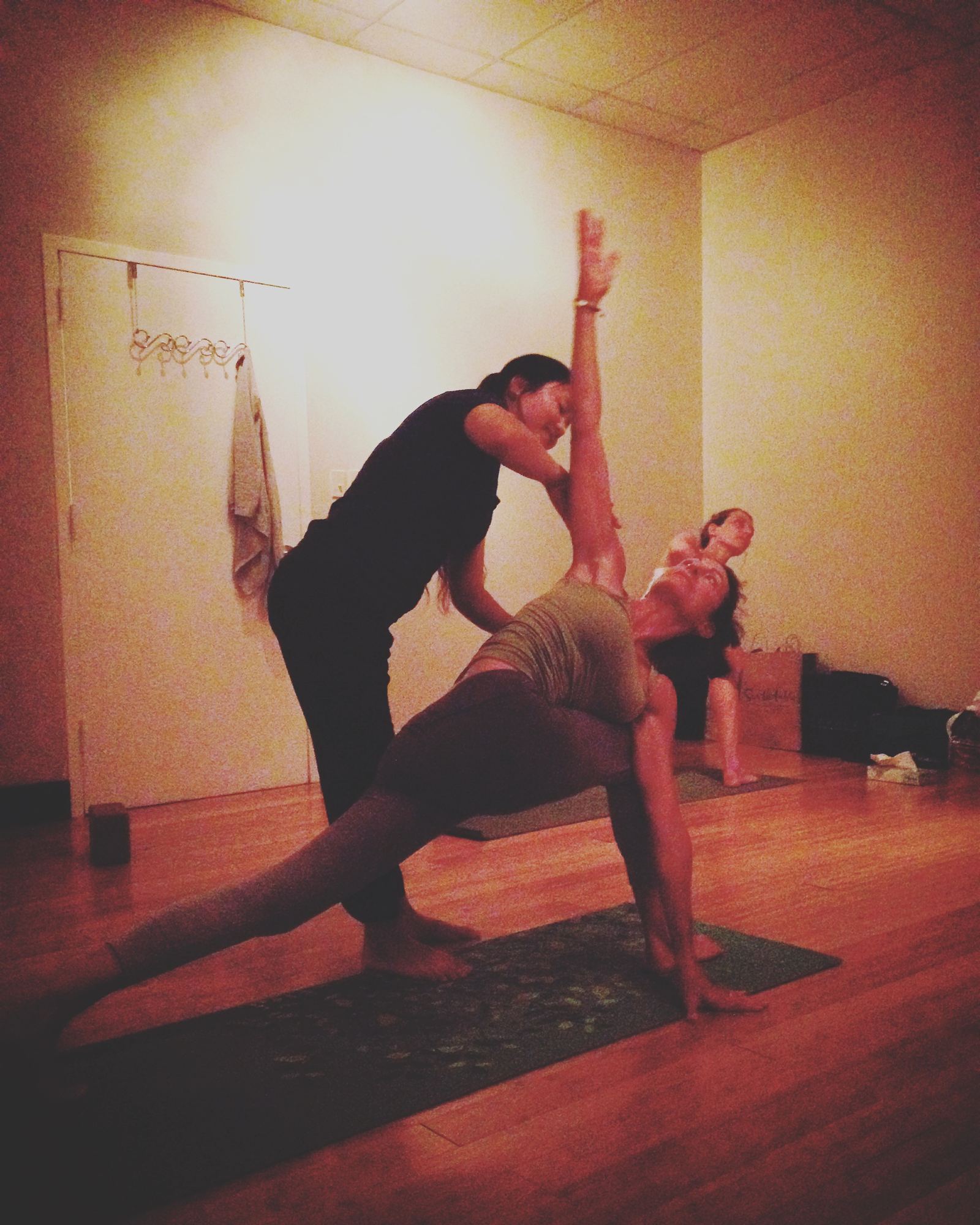 Teacher offering a hands-on assist in extended side angle pose