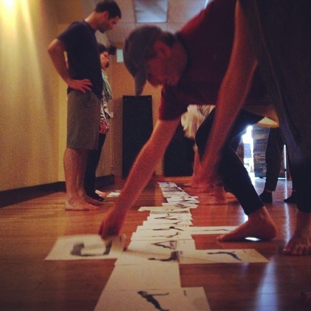 Yoga teacher training students arranging sequence cards on the studio floor in Rockville Centre