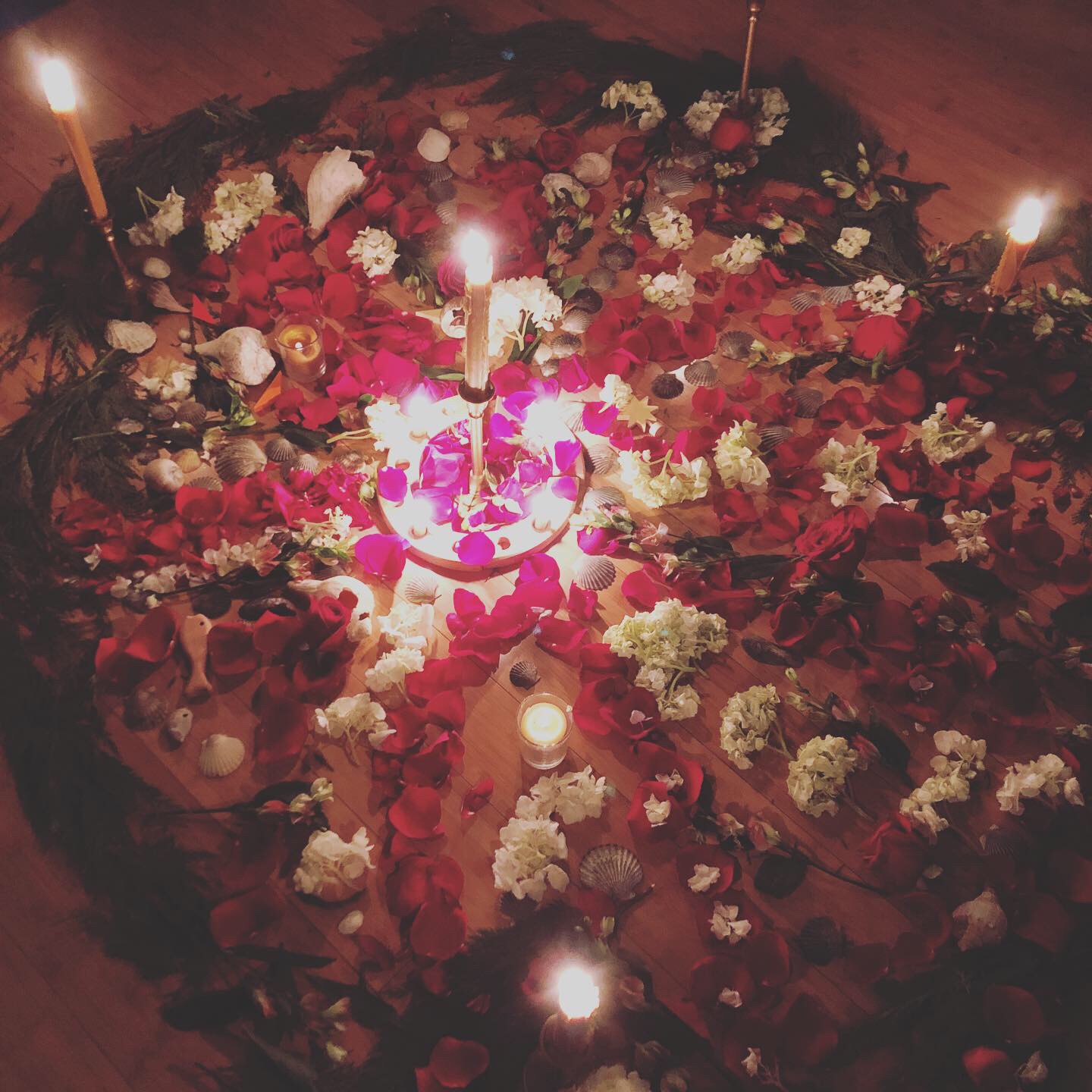 Candlelit altar with petals and shells