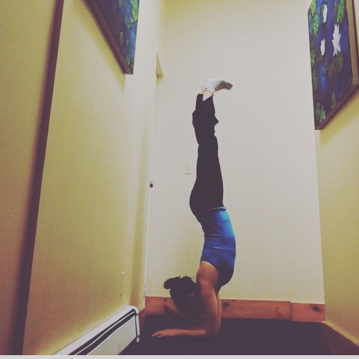 Yogi practicing headstand against a wall