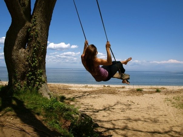 Amanda DiGiovanna on a rope swing by the ocean