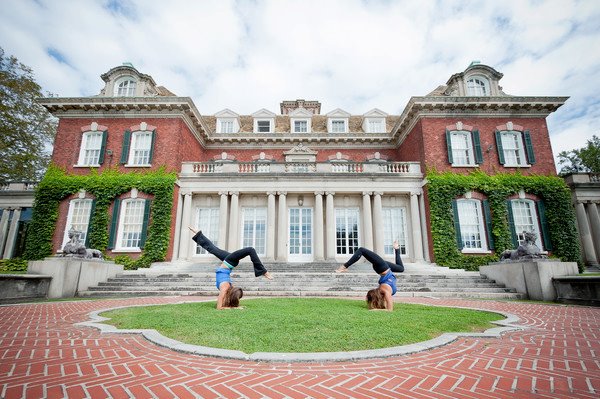 Amanda DiGiovanna and a friend in handstands in front of a mansion