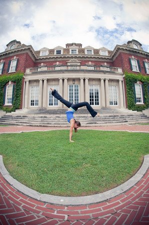 Amanda DiGiovanna in a handstand in front of a historic mansion