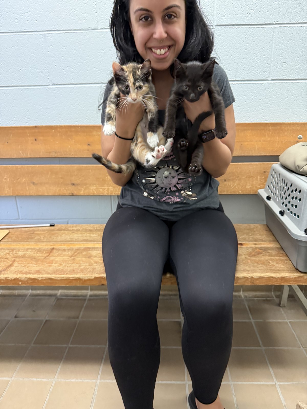 Basma smiling and holding two kittens