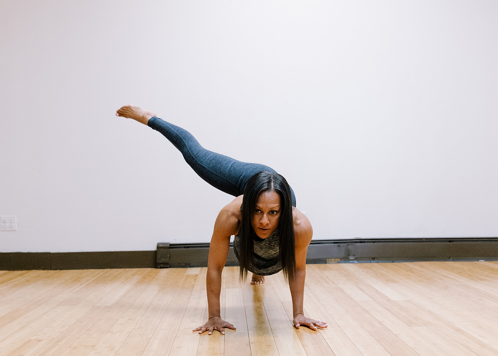 Jen Myers in an arm balance with one leg extended