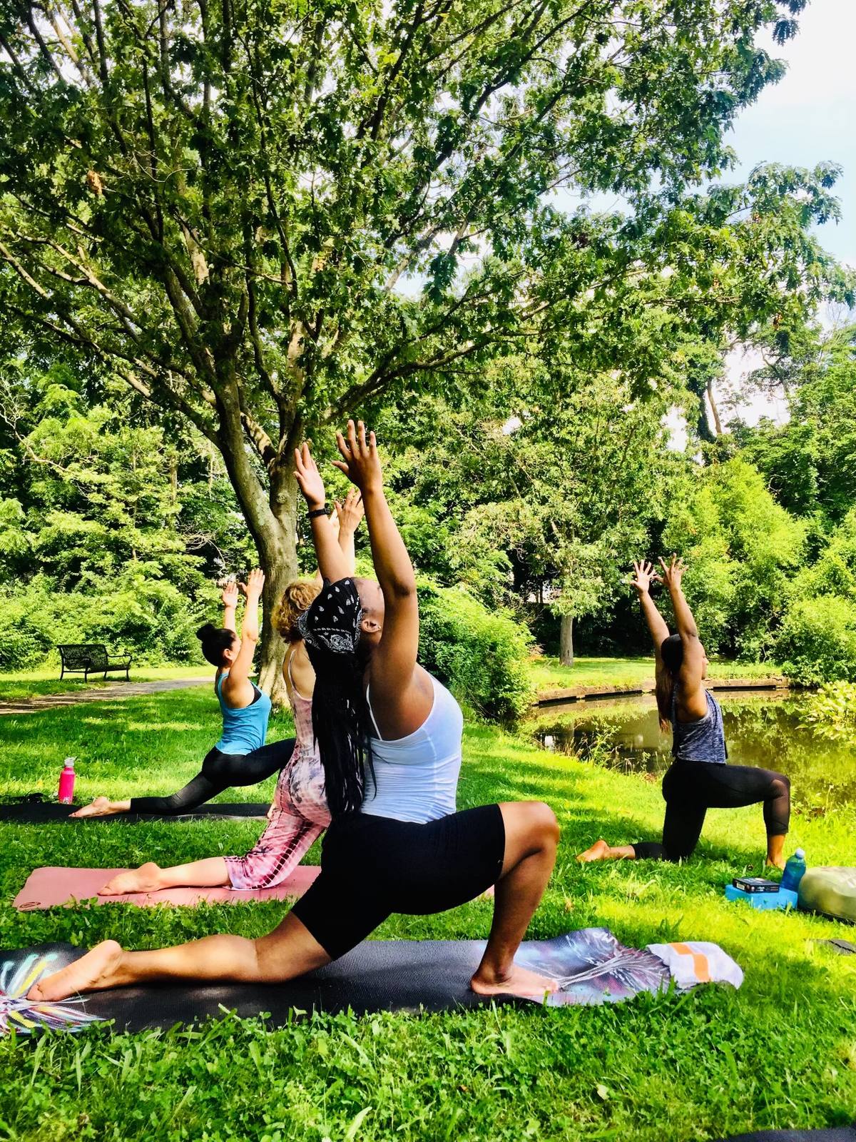 Jen Myers teaching a low lunge in a park