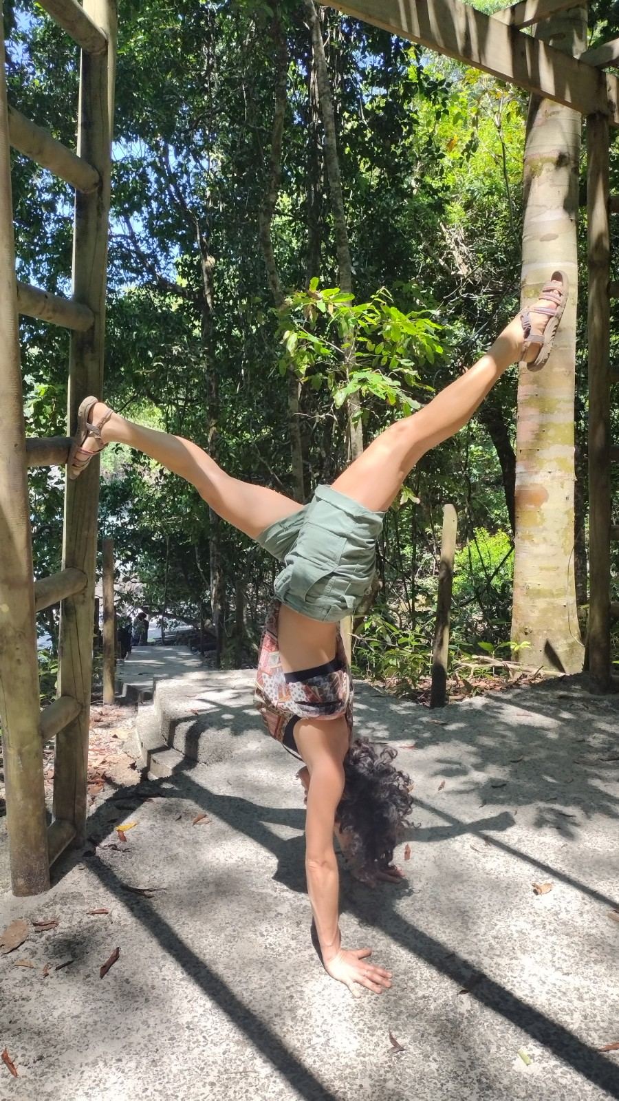 Micheline DeBono in an inverted pose in a garden
