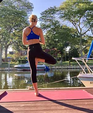 Michelle Levitsky in tree pose on a dock
