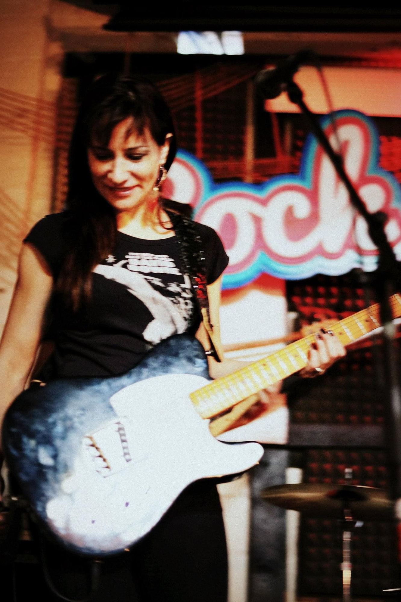 Paola Luna playing electric guitar on stage