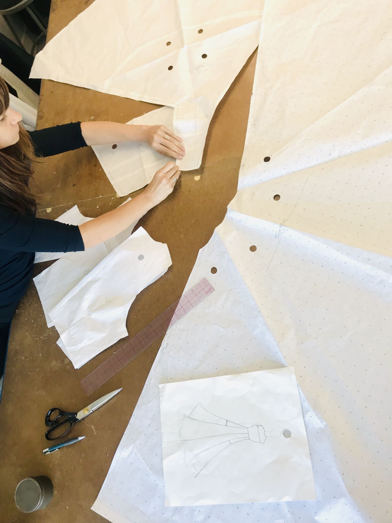 Paola Luna cutting sewing patterns in her design studio