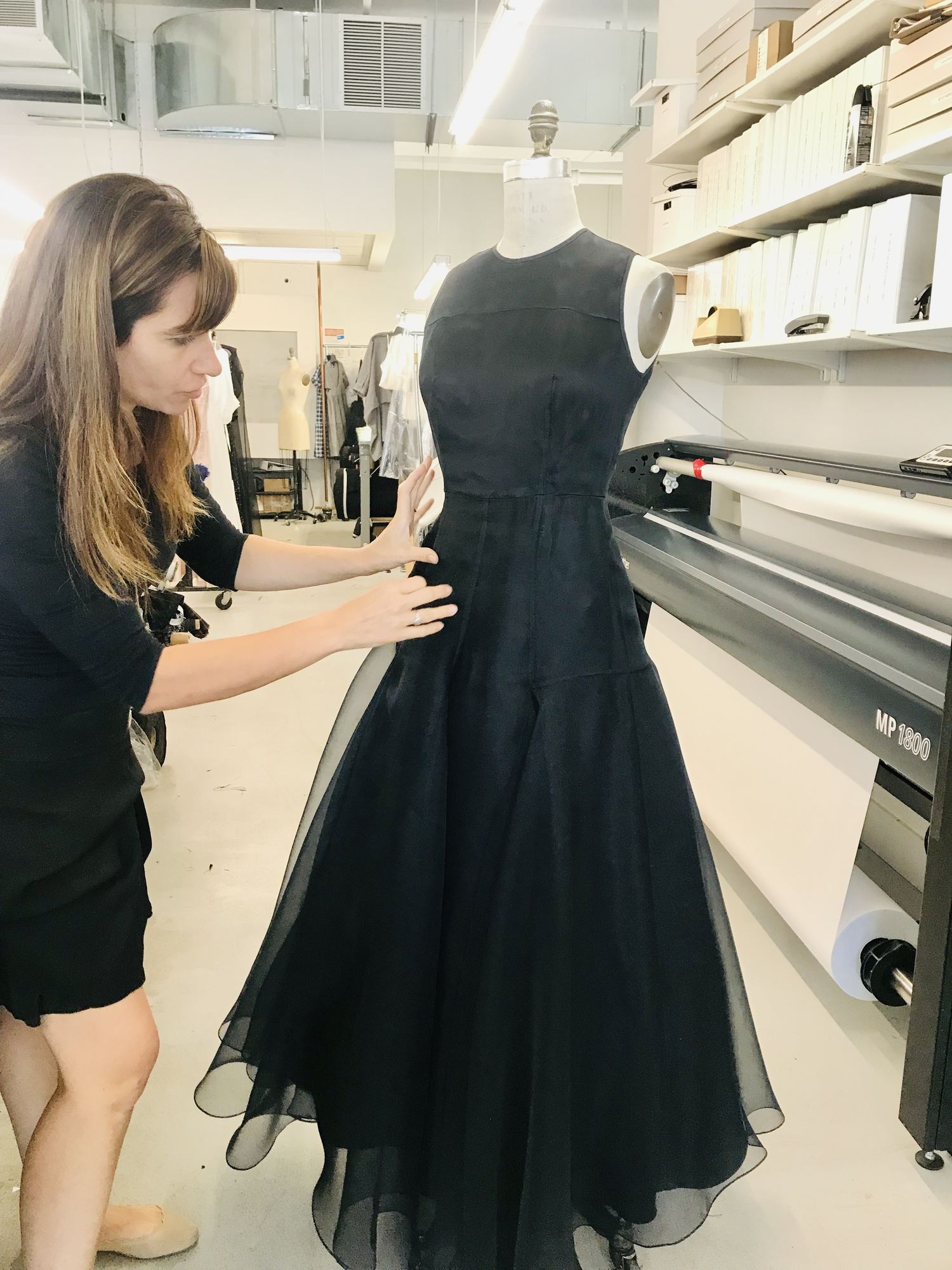 Paola Luna fitting a black gown on a dress form