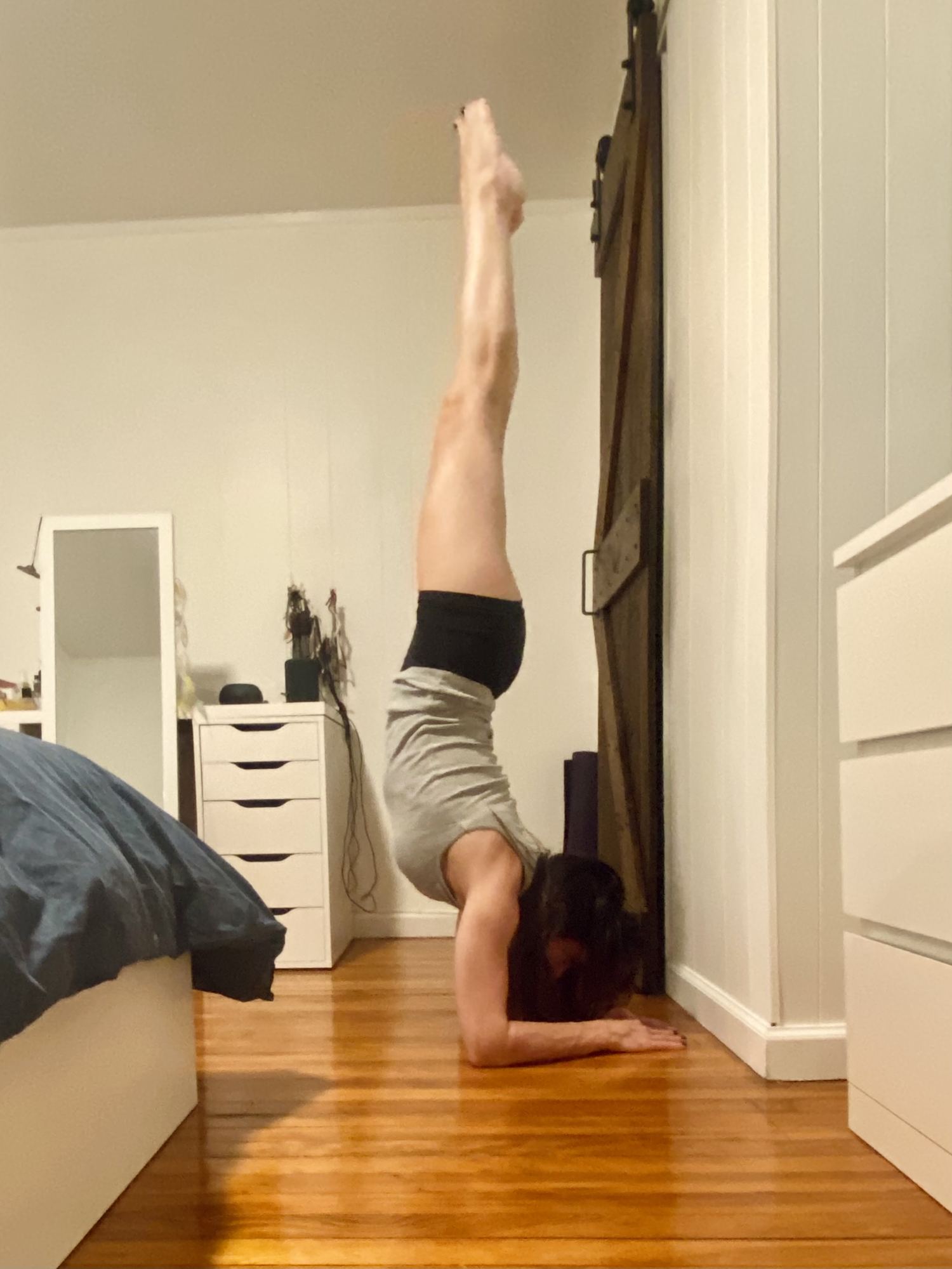 Paola Luna in a forearm stand against a wall