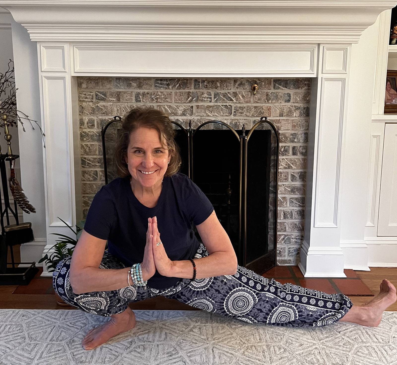 Pauline Festa seated by a fireplace with hands at heart
