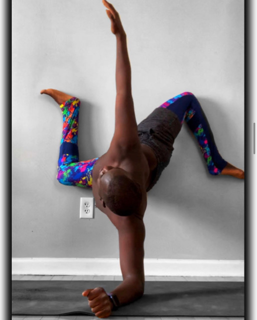 Rahmon Habeeb in a one-arm balance against a wall